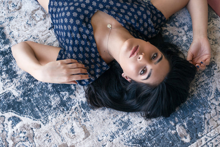 woman-poses-on-blue-patterned-rug